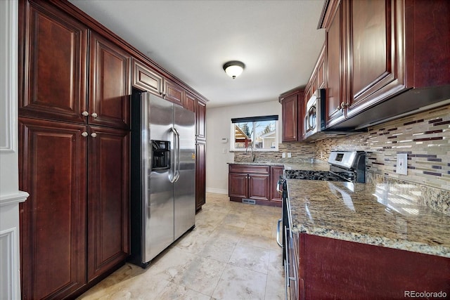 kitchen featuring decorative backsplash, light stone countertops, sink, and appliances with stainless steel finishes