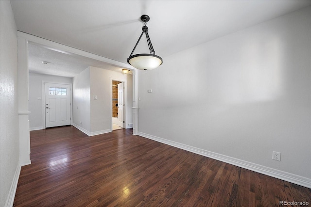 empty room with dark hardwood / wood-style flooring