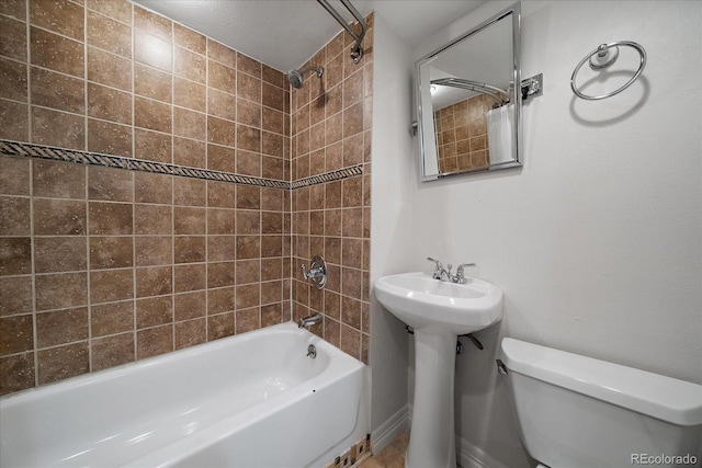 full bathroom with toilet, tiled shower / bath, and sink