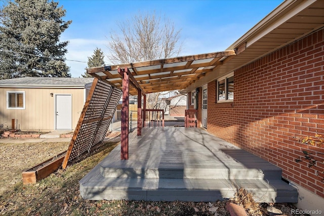 view of patio / terrace with a wooden deck and an outbuilding