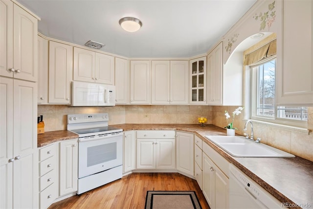 1030 Krameria St, Denver, CO 80220 - kitchen featuring white appliances, a sink, backsplash, light wood-type flooring, and glass insert cabinets