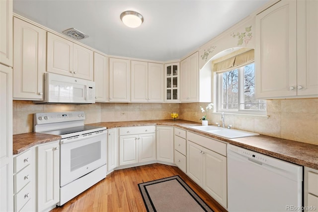 1030 Krameria St, Denver, CO 80220 - kitchen with white appliances, a sink, light wood finished floors, decorative backsplash, and glass insert cabinets