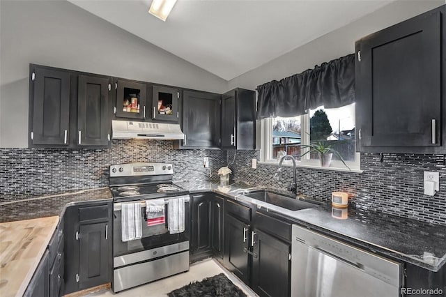 kitchen with appliances with stainless steel finishes, tasteful backsplash, vaulted ceiling, sink, and butcher block counters