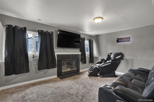 living room with a fireplace, carpet floors, and a textured ceiling