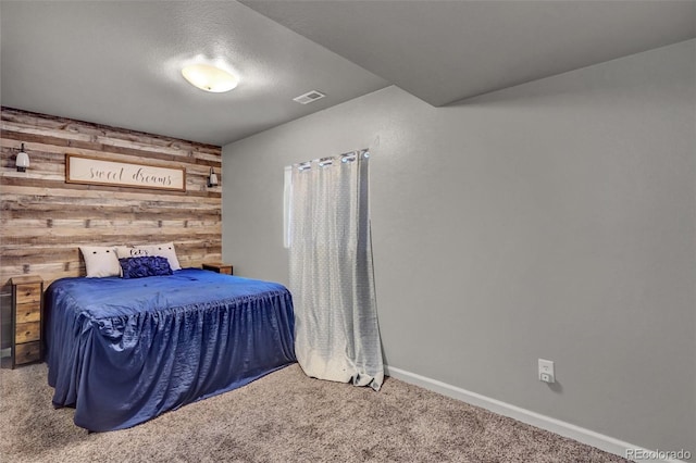 carpeted bedroom with wood walls