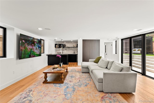 220 Glencoe St, Denver, CO 80220 - living area featuring wet bar, light wood-type flooring, baseboards, and recessed lighting