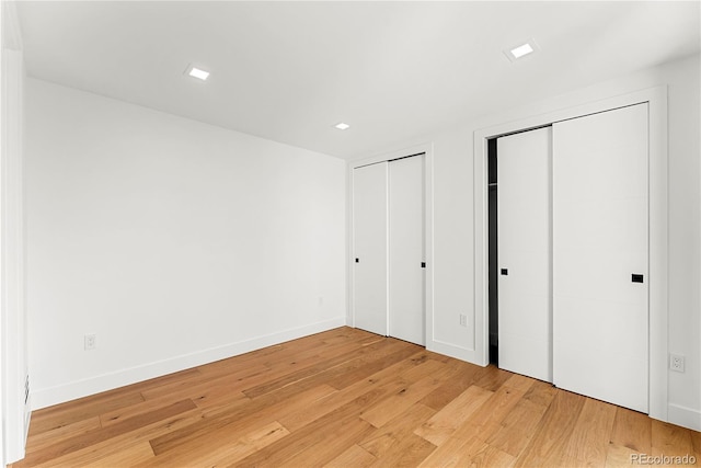 220 Glencoe St, Denver, CO 80220 - unfurnished bedroom with two closets, light wood finished floors, and baseboards
