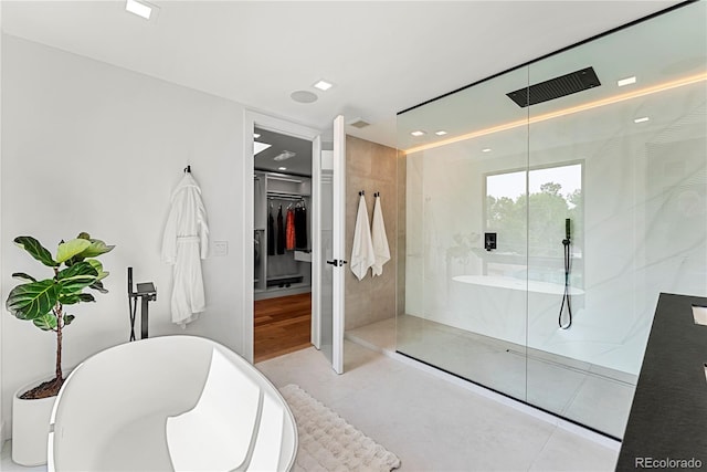 220 Glencoe St, Denver, CO 80220 - bathroom with a walk in shower, a spacious closet, tile patterned flooring, recessed lighting, and a freestanding tub
