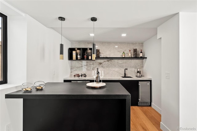 220 Glencoe St, Denver, CO 80220 - indoor wet bar with tasteful backsplash, light wood-type flooring, decorative light fixtures, and baseboards
