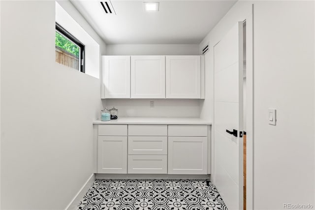 220 Glencoe St, Denver, CO 80220 - kitchen with light countertops, white cabinets, light tile patterned floors, and baseboards