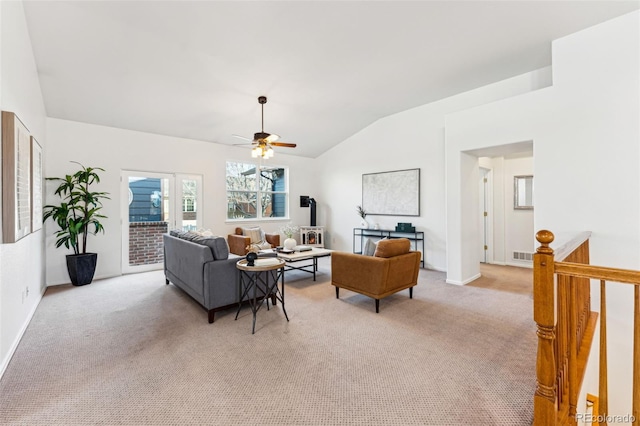 living area with a ceiling fan, visible vents, baseboards, lofted ceiling, and light colored carpet