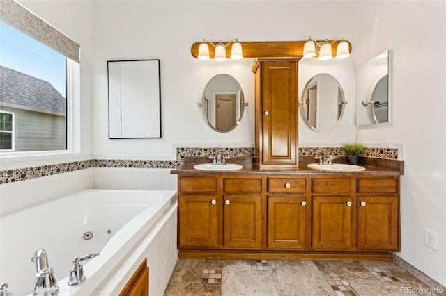 full bathroom with double vanity, a whirlpool tub, and a sink