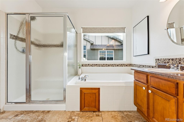 full bathroom featuring vanity, a garden tub, and a stall shower