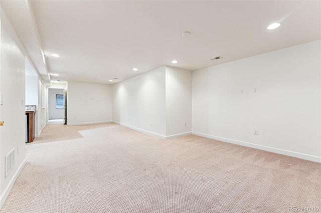 empty room with recessed lighting, visible vents, and light carpet