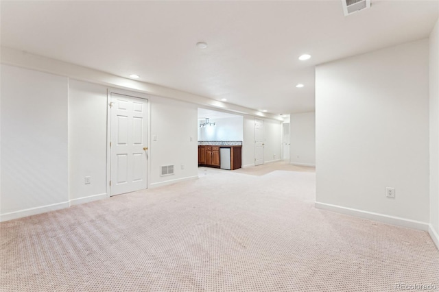 finished basement with visible vents, recessed lighting, and light colored carpet