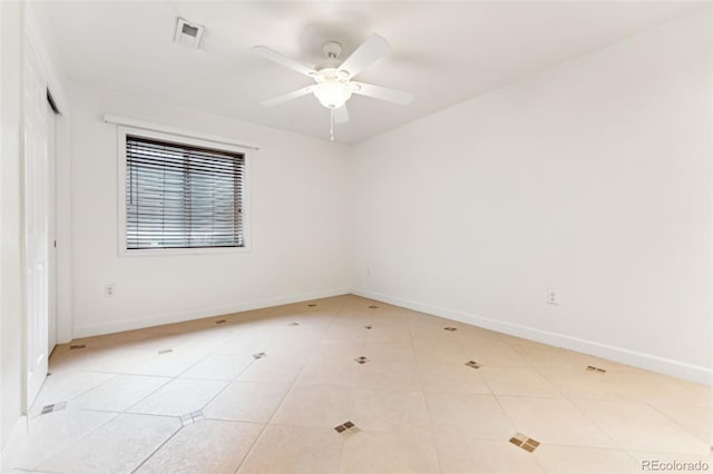 unfurnished room with light tile patterned floors, a ceiling fan, visible vents, and baseboards