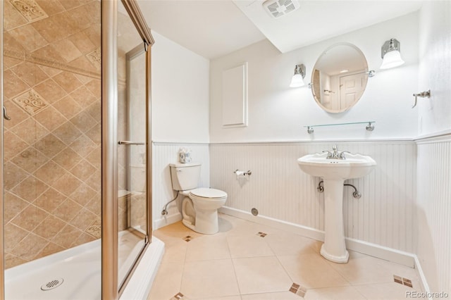 full bathroom with tile patterned floors, visible vents, toilet, and a wainscoted wall