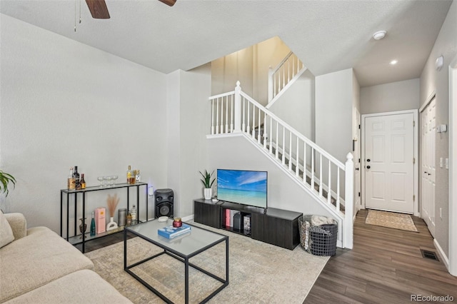 living room featuring baseboards, visible vents, stairway, wood finished floors, and recessed lighting