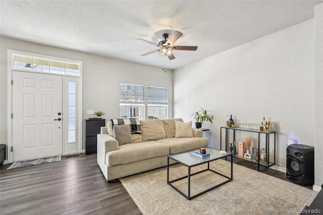 living area featuring a textured ceiling, a ceiling fan, and wood finished floors