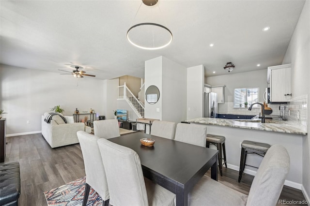 dining room with dark wood-type flooring, recessed lighting, stairway, and baseboards