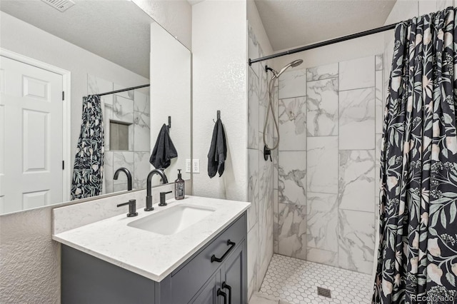 bathroom with a textured ceiling, vanity, and a shower with curtain