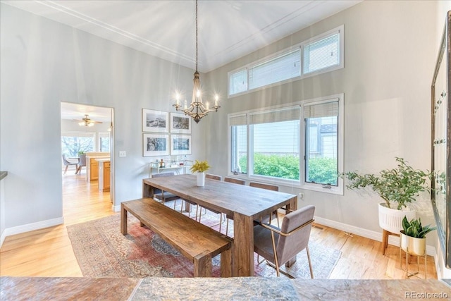 58 Rogers Ct, Golden, CO 80401 - dining area with a towering ceiling, a chandelier, light wood-type flooring, and baseboards