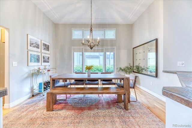 58 Rogers Ct, Golden, CO 80401 - dining space featuring a chandelier, wood finished floors, baseboards, a towering ceiling, and arched walkways