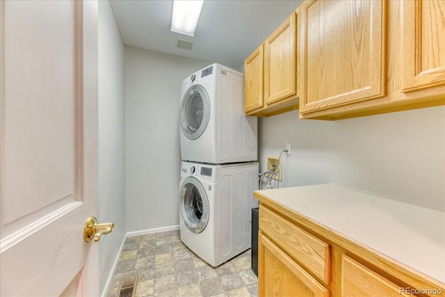 58 Rogers Ct, Golden, CO 80401 - laundry area with estacked washer and dryer, cabinet space, and baseboards