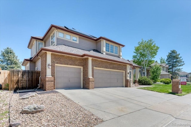58 Rogers Ct, Golden, CO 80401 - view of front of property featuring solar panels, brick siding, concrete driveway, fence, and a garage