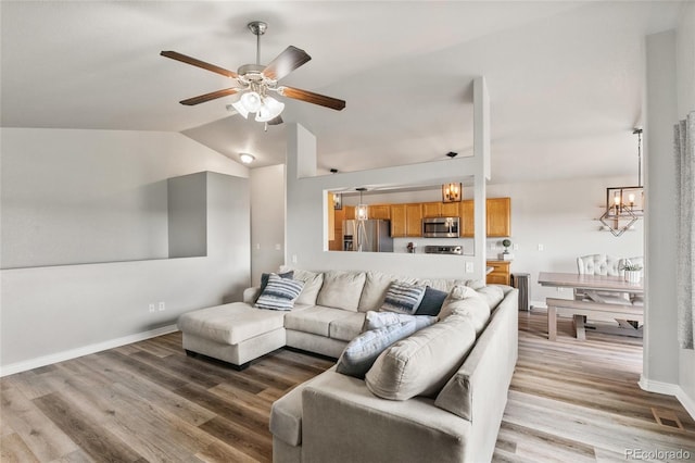 8617 W 17th Street Dr, Greeley, CO 80634 - living room with a ceiling fan, lofted ceiling, a chandelier, light wood-style floors, and baseboards