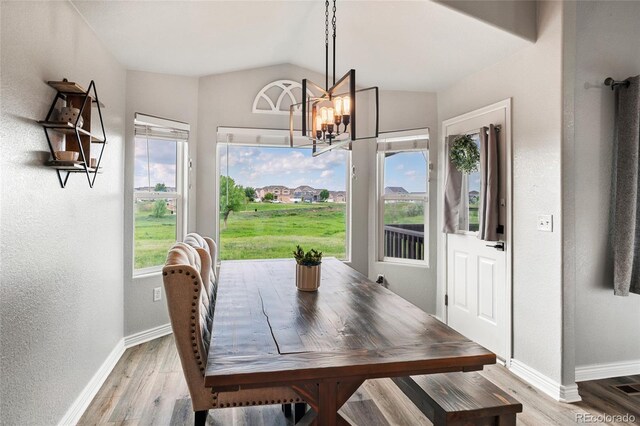 8617 W 17th Street Dr, Greeley, CO 80634 - dining room featuring baseboards, a chandelier, light wood-style flooring, and lofted ceiling