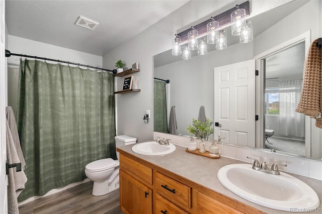 8617 W 17th Street Dr, Greeley, CO 80634 - bathroom with toilet, wood finished floors, double vanity, and curtained shower