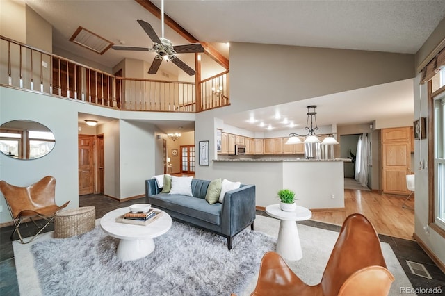 living room featuring plenty of natural light, high vaulted ceiling, and light hardwood / wood-style flooring