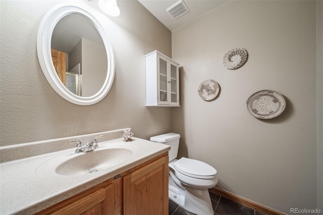 bathroom featuring tile patterned flooring, vanity, and toilet