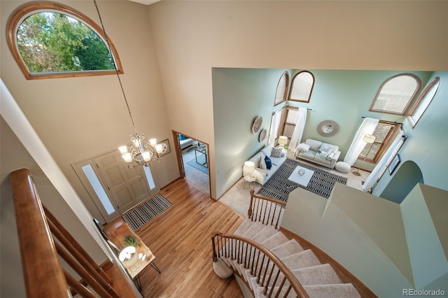 foyer entrance with a notable chandelier, a high ceiling, and light hardwood / wood-style flooring