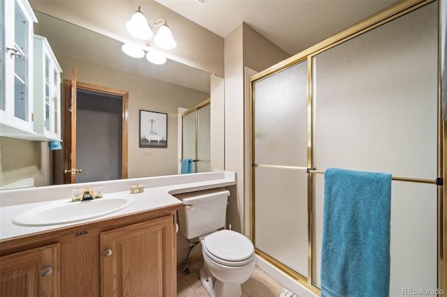 bathroom with vanity, a shower with shower door, and toilet