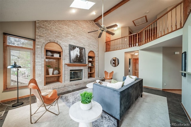 tiled living room featuring a skylight, a brick fireplace, built in shelves, ceiling fan, and high vaulted ceiling