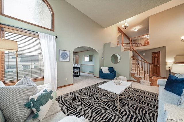 living room featuring high vaulted ceiling, light colored carpet, and a notable chandelier