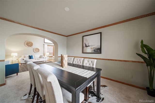 dining area featuring light carpet and crown molding