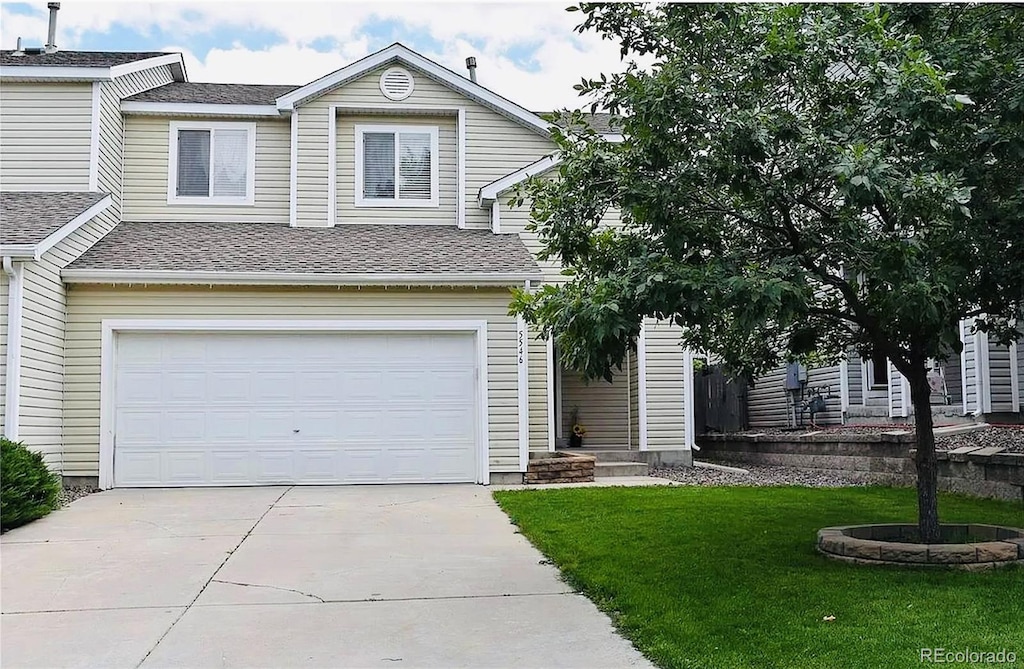 5546 S Quemoy Cir, Aurora, CO 80015 - view of front of property with a garage, driveway, a front yard, and roof with shingles