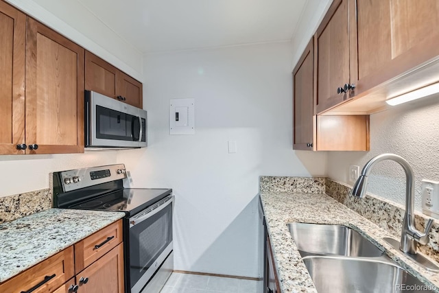 kitchen with sink, stainless steel appliances, and light stone counters