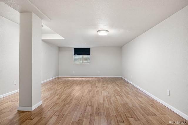 empty room with light wood-type flooring and baseboards
