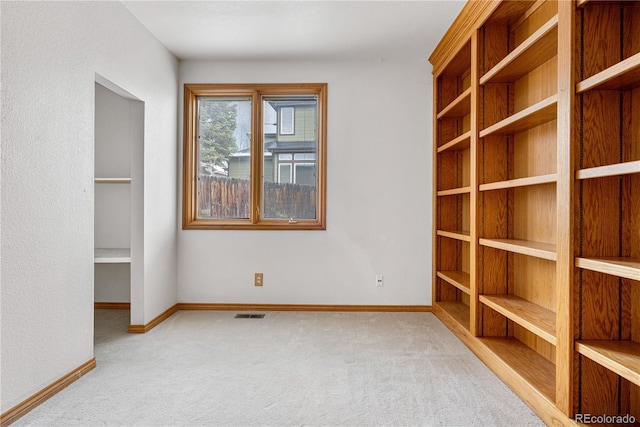 spare room featuring visible vents, baseboards, and carpet flooring