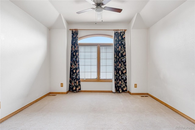 carpeted spare room with baseboards and a ceiling fan