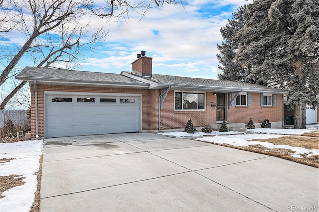 single story home featuring brick siding, a chimney, a shingled roof, concrete driveway, and a garage