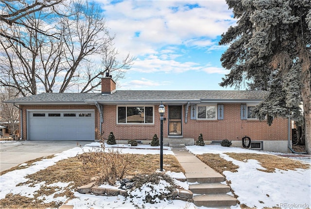 single story home featuring a garage, a chimney, and brick siding