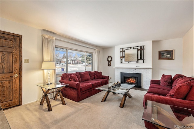 living area featuring a brick fireplace and carpet