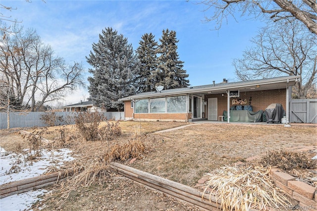 view of front of house with brick siding and a fenced backyard