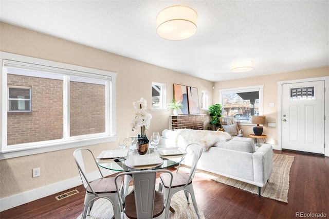 dining room featuring visible vents, baseboards, and dark wood-style flooring