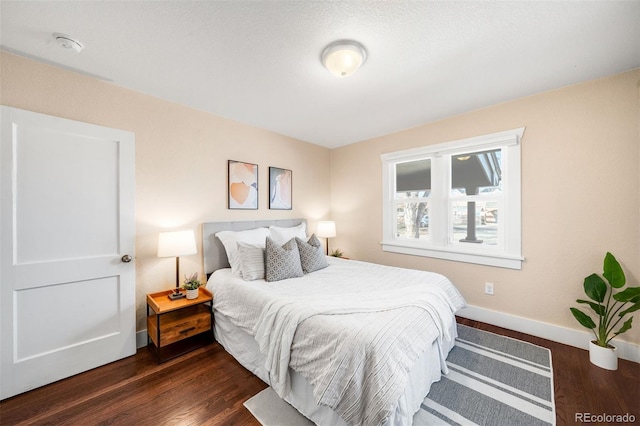 bedroom featuring dark wood-style floors and baseboards